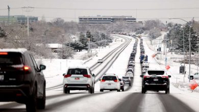 Traffic stacks up on 5300 South in Taylorsville as snow falls along the Wasatch Front on Friday.