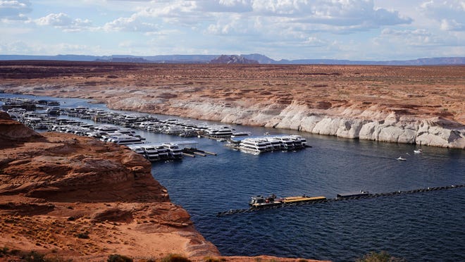 A white band of newly exposed rock is shown along the canyon walls at Lake Powell at Antelope Point Marina on Friday, July 30, 2021, near Page, Ariz. It highlights the difference between today's lake level and the lake's high-water mark. This summer, the water levels hit a historic low amid a climate change-fueled megadrought engulfing the U.S. West. (AP Photo/Rick Bowmer)