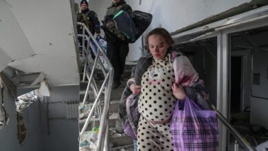 An injured pregnant woman, identified as Podgurskaya in multiple reports, walks downstairs in a maternity hospital damaged by shelling in Mariupol, Ukraine, Wednesday, March 9, 2022.