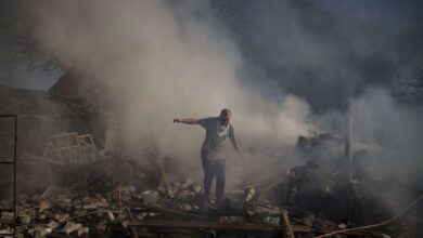 A man walks on the debris of a burning house, destroyed after a Russian attack in Kharkiv, Ukraine, Thursday. About 300 people were killed in the Russian airstrike last week that blasted open a Mariupol theater, Ukrainian authorities said Friday, in what would make it the war’s deadliest known attack on civilians yet.