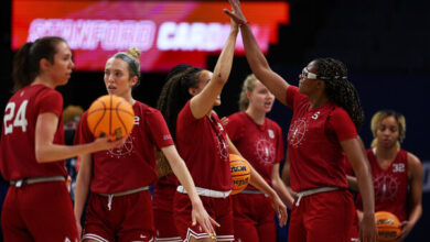 Francesa Belibi, wearing No. 5 at right, high-fiving Haley Jones during a practice for Stanford in Minneapolis on Thursday ahead of a Final Four game against Connecticut on Friday.